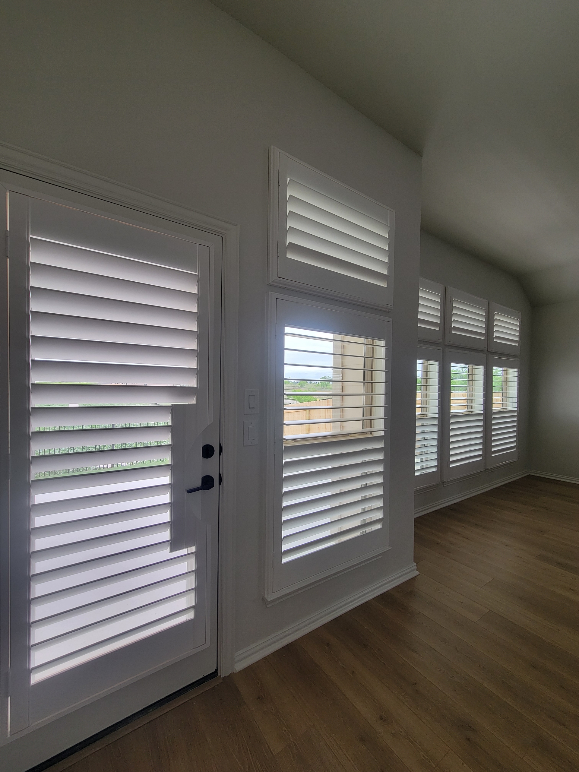 Plantation shutters across an entire wall in a new build DFW home