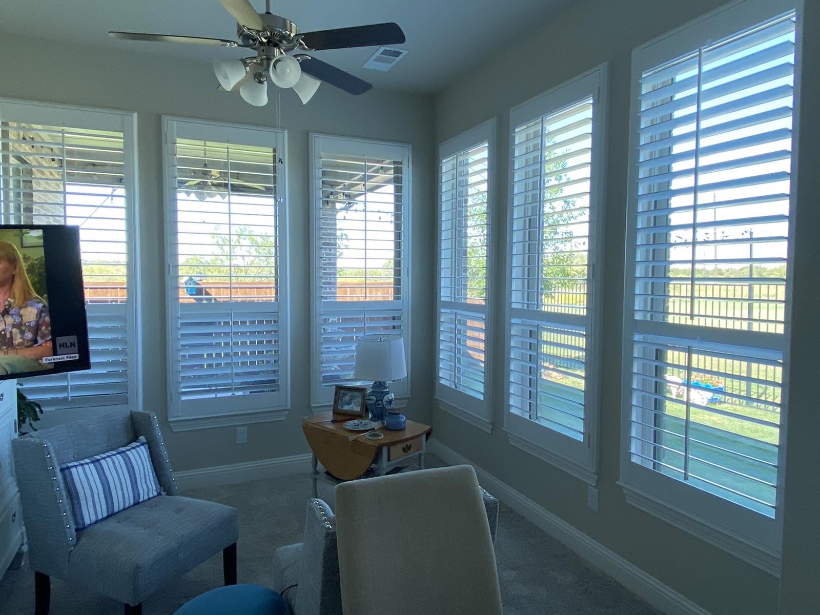 Plantation shutters filling a bright sunroom